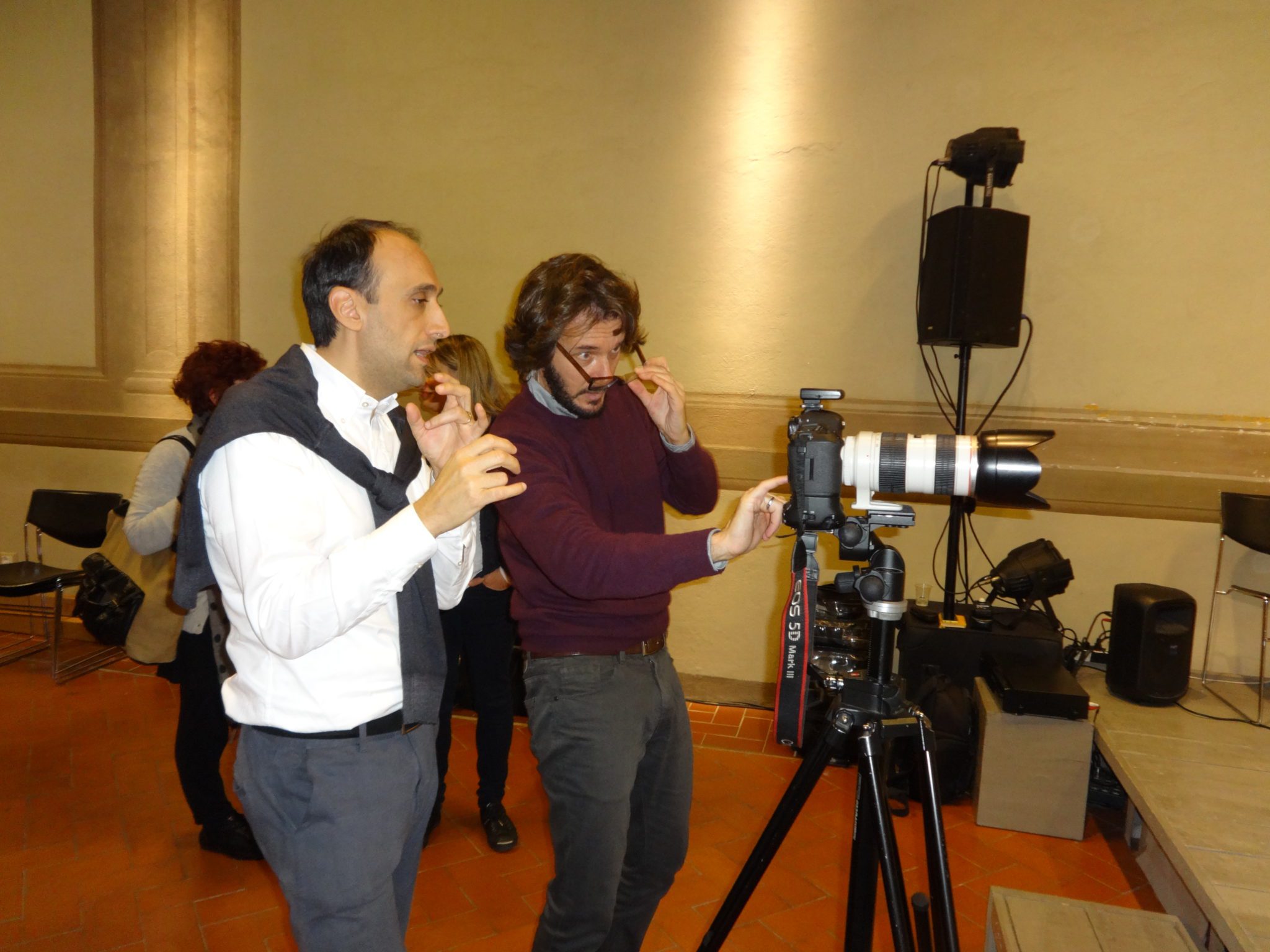 Un'immagine che ritrae fotocamere e ottiche, telecamera, pantaloni, videocamera e fotografo.