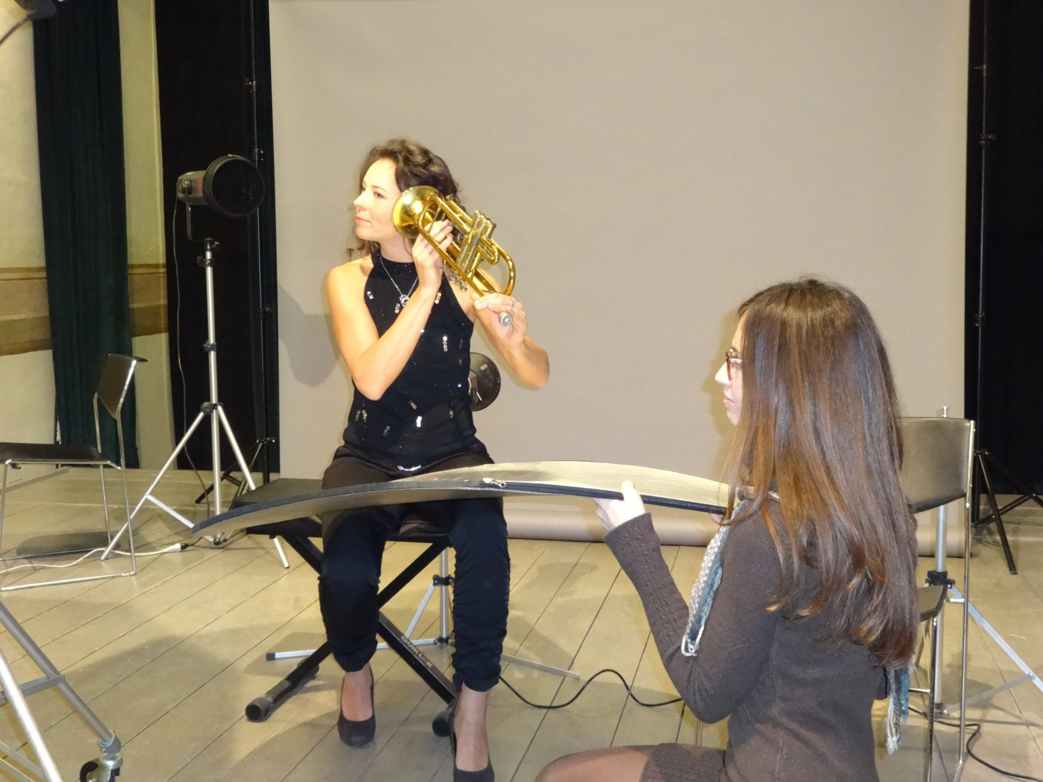 Un'immagine che ritrae strumento musicale, musicista, strumento in ottone, leggio e aerofono.
