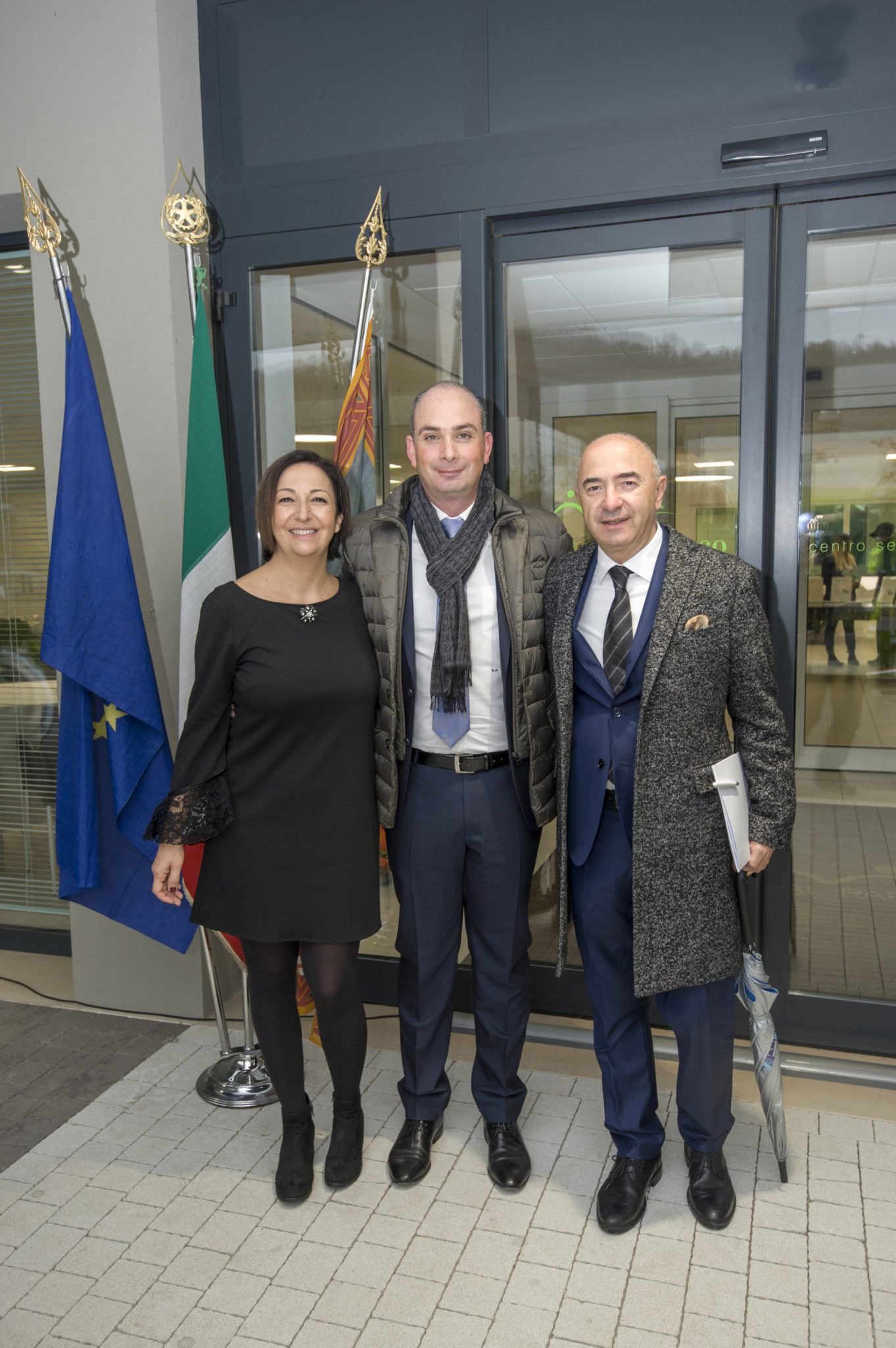 Un'immagine che ritrae sorriso, capispalla, pantaloni, in piedi e abbigliamento formale.